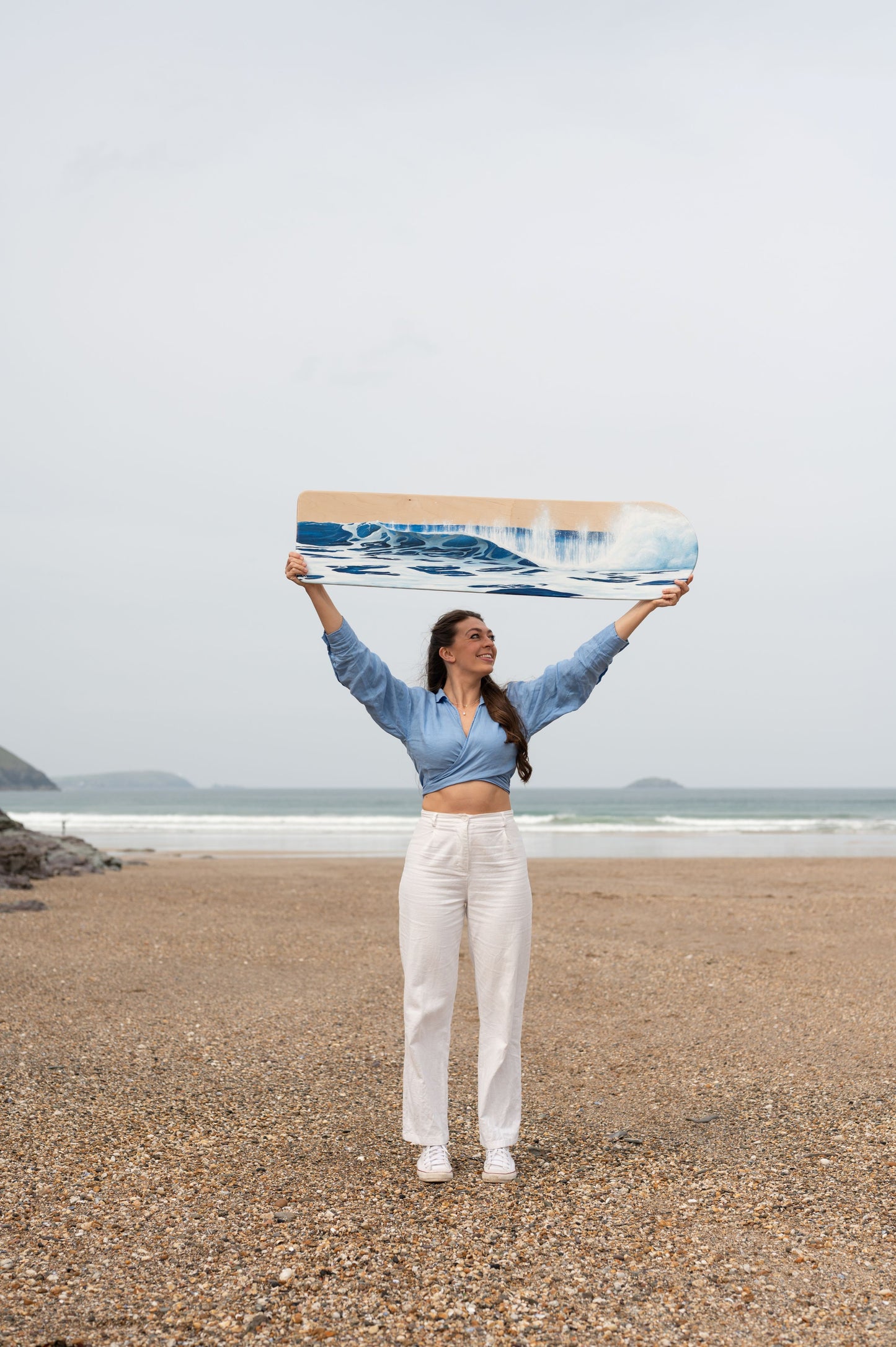 Cornish artist, Phoebe Pocock, at Polzeath with oil painted wooden bellyboard