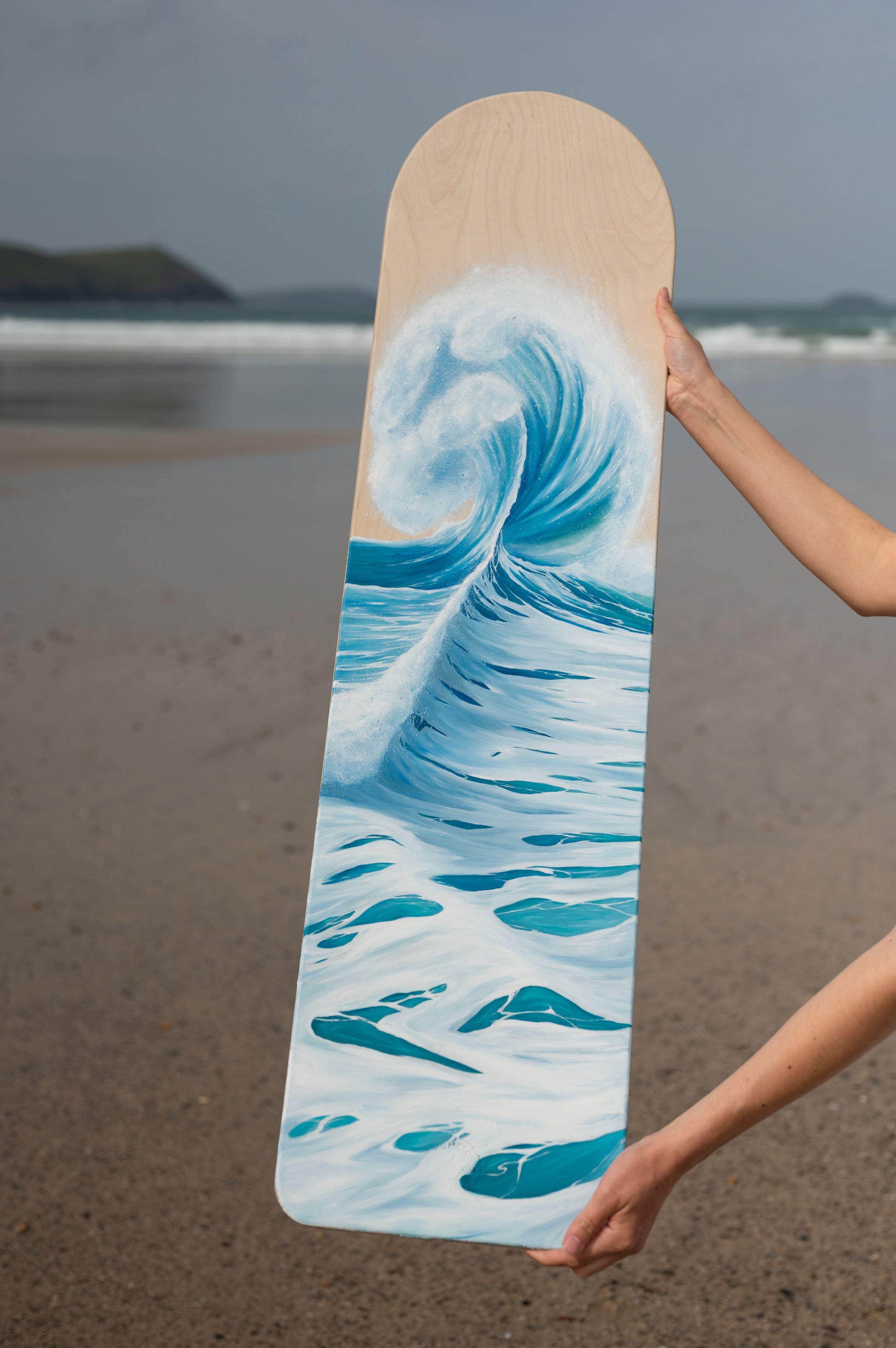 wave painting on wooden bellyboard at Polzeath beach by cornish artist, Phoebe Pocock